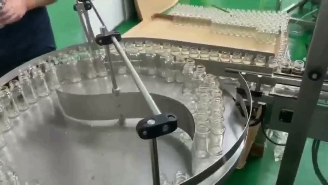 Riordinatore rotativo che alimenta piccoli flaconi su una linea automatica